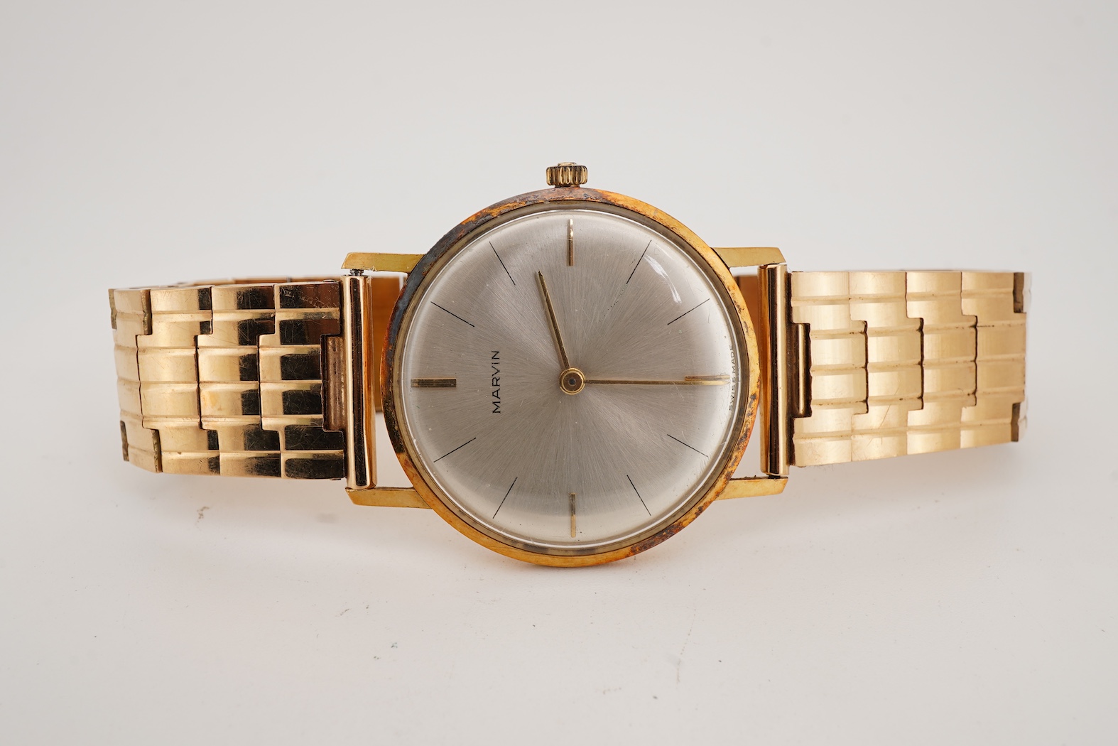 A gentleman's Swiss 18k gold Marvin manual wind dress wrist watch, with a Swiss 18k gold fancy brick link bracelet
